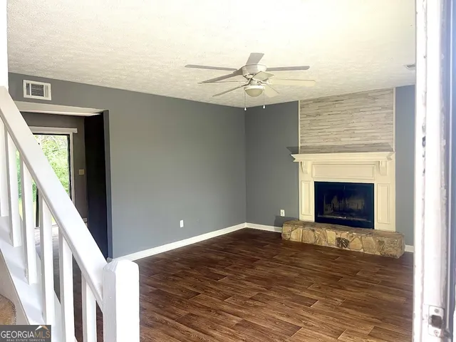 a view of an empty room with window and wooden floor