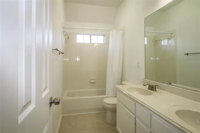 a bathroom with a granite countertop sink a toilet and shower