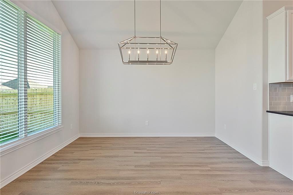 3124 Tarleton Court Bryan, TX 77808 - Photo 9 of 22 a view of an empty room with wooden floor and a window