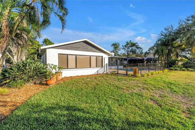 a view of a house with a small yard and swimming pool