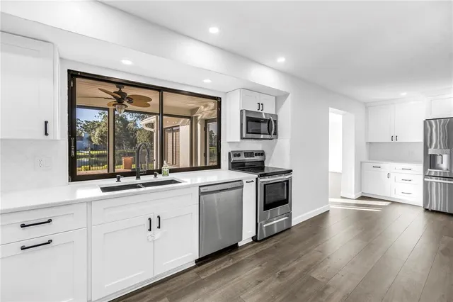 a kitchen with stainless steel appliances a white stove top oven and refrigerator