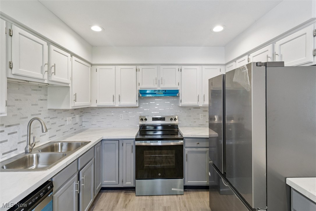 3930 Wood Road Madison, OH 44057 - Photo 17 of 45 Kitchen featuring gray cabinets, appliances with stainless steel finishes, tasteful backsplash, white cabinets, and recessed lighting