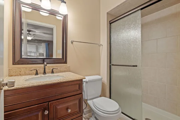 a bathroom with a sink a toilet a mirror and shower