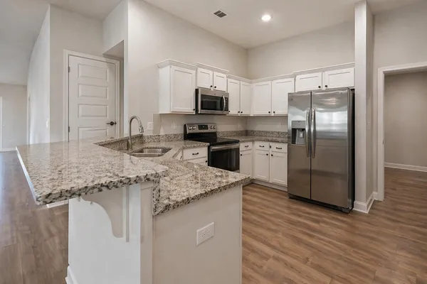 a kitchen with stainless steel appliances granite countertop a sink refrigerator and microwave