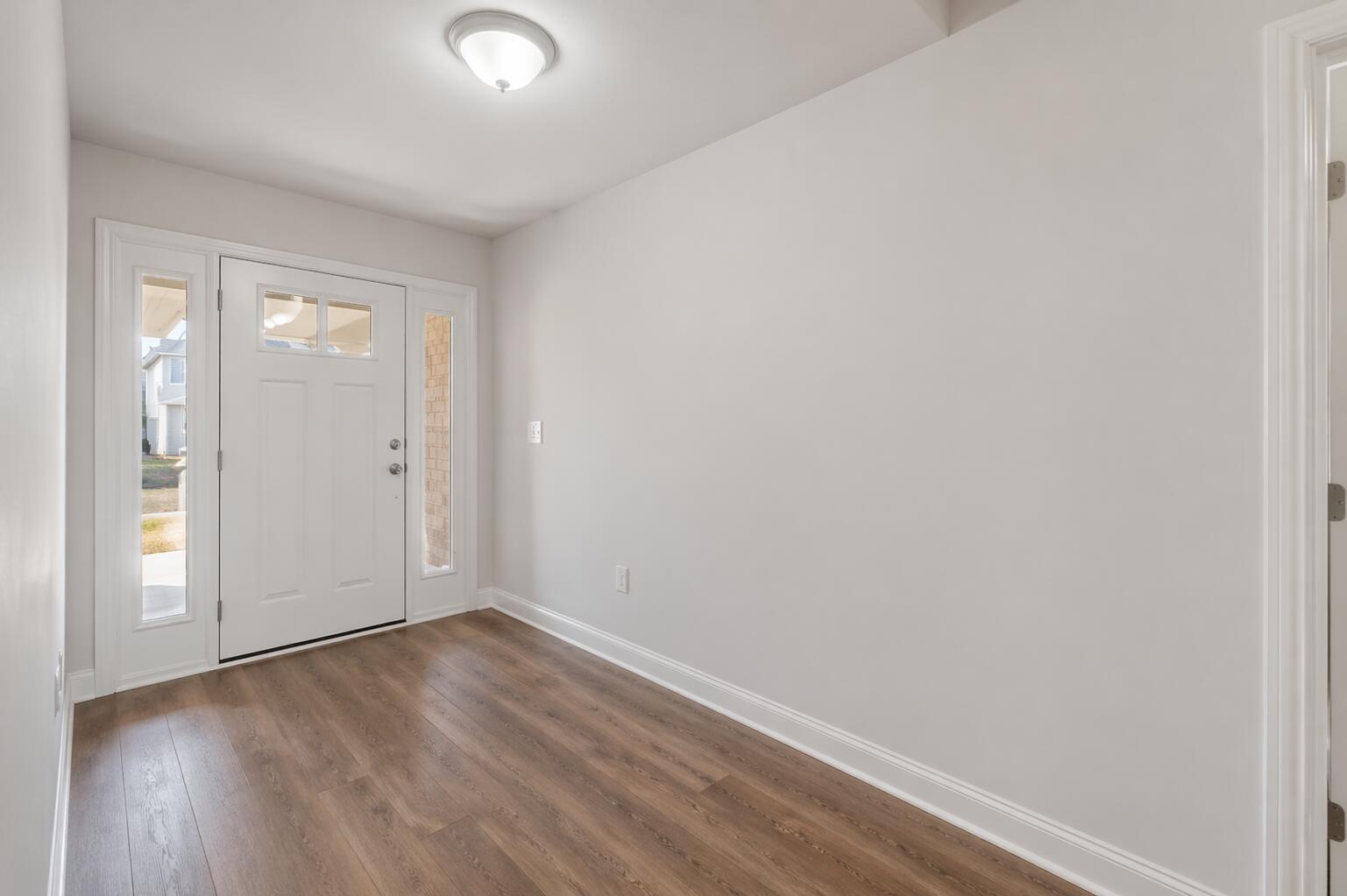 109 Ridgeway Circle Crestview, FL 32536 - Photo 4 of 18 an empty room with wooden floor and windows