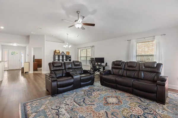 a view of a dining room with furniture a chandelier and wooden floor