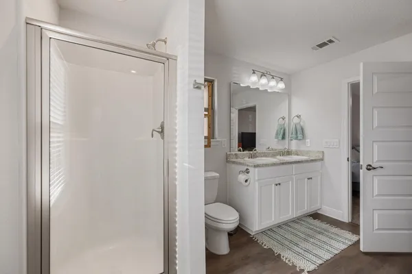a bathroom with a granite countertop sink toilet and shower