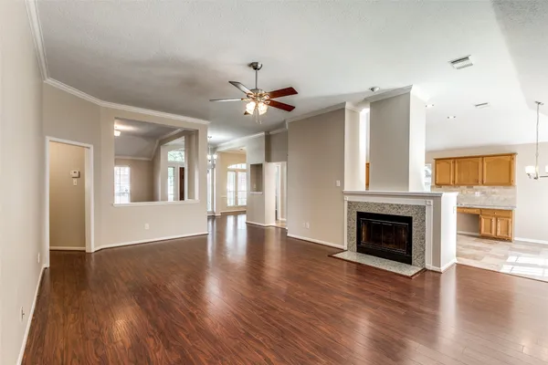 a view of an empty room with wooden floor and a fireplace
