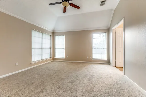 an empty room with windows and fan