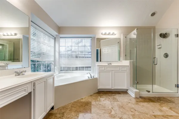a bathroom with a tub sink shower and mirror