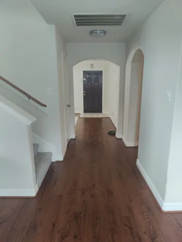 a view of a hallway with wooden floor and a window