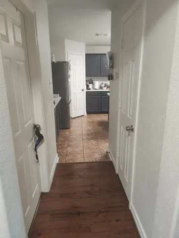 a kitchen with a refrigerator a stove top oven and wooden floor
