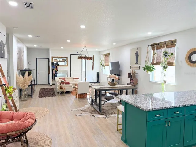 a living room with furniture a wooden floor and a bookshelf