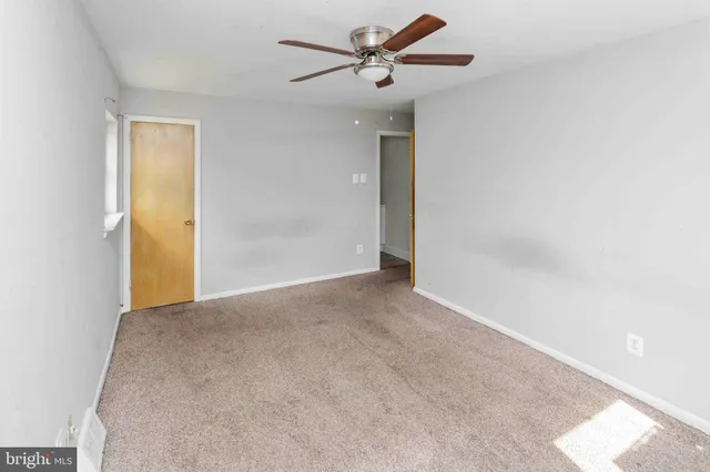 a view of empty room with ceiling fan