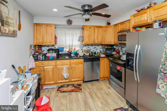 a kitchen with stainless steel appliances a stove a refrigerator and a dining table