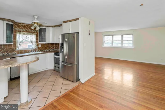 a kitchen with granite countertop a refrigerator and a stove top oven