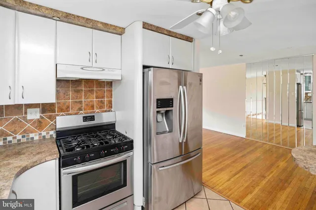 a kitchen with granite countertop a stove and a refrigerator with cabinets