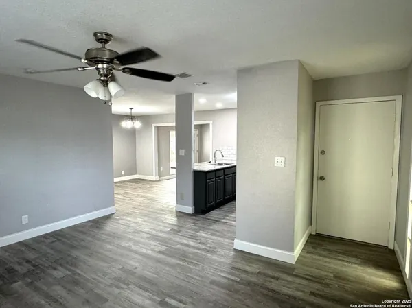 a view of a big room with wooden floor and windows