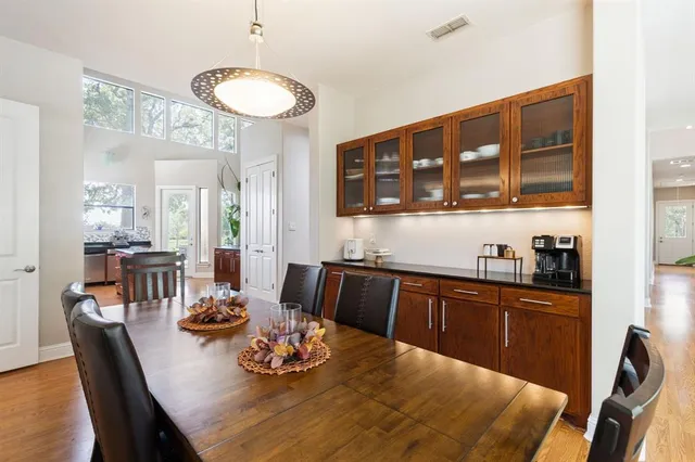 a kitchen with stainless steel appliances granite countertop a dining table chairs and view of living room