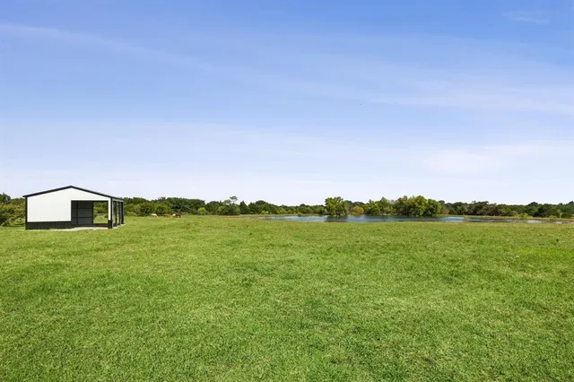 a view of big green field with mountains in the background