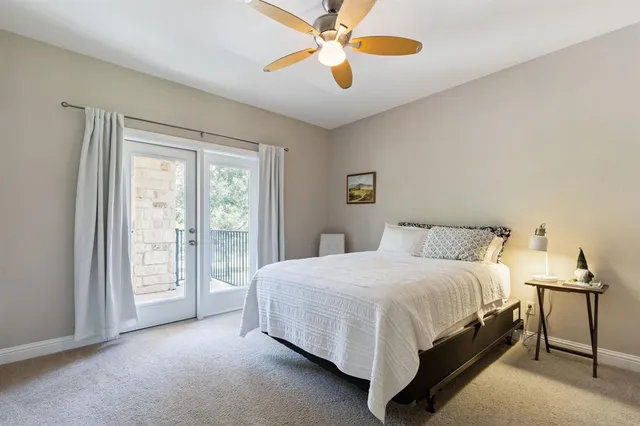 a bedroom with a bed lamp and a large window