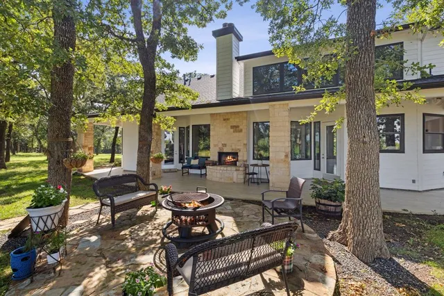 a view of a patio with couches table and chairs and a large tree