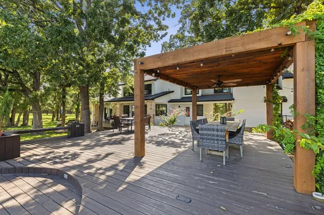 a patio with wooden floor table and chairs