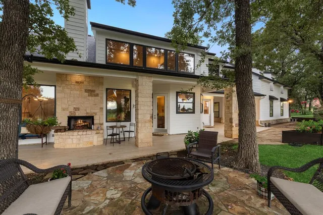 a view of a patio with table and chairs potted plants and a large tree