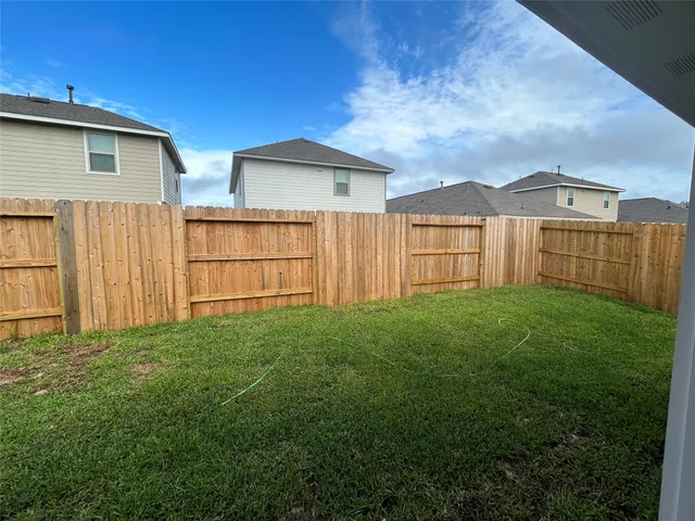 a view of backyard of house with green space