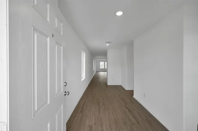 a view of a hallway with wooden floor
