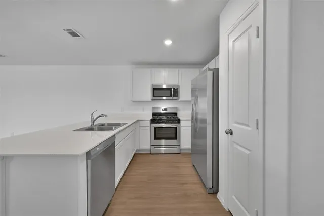a kitchen with a sink and steel stainless steel appliances