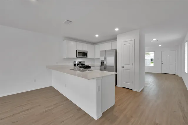 a view of kitchen with wooden floor and electronic appliances