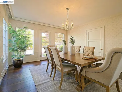 a view of a dining room with furniture a chandelier and wooden floor