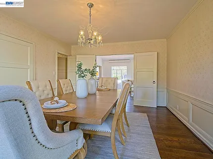 a view of a dining room with furniture a chandelier and wooden floor