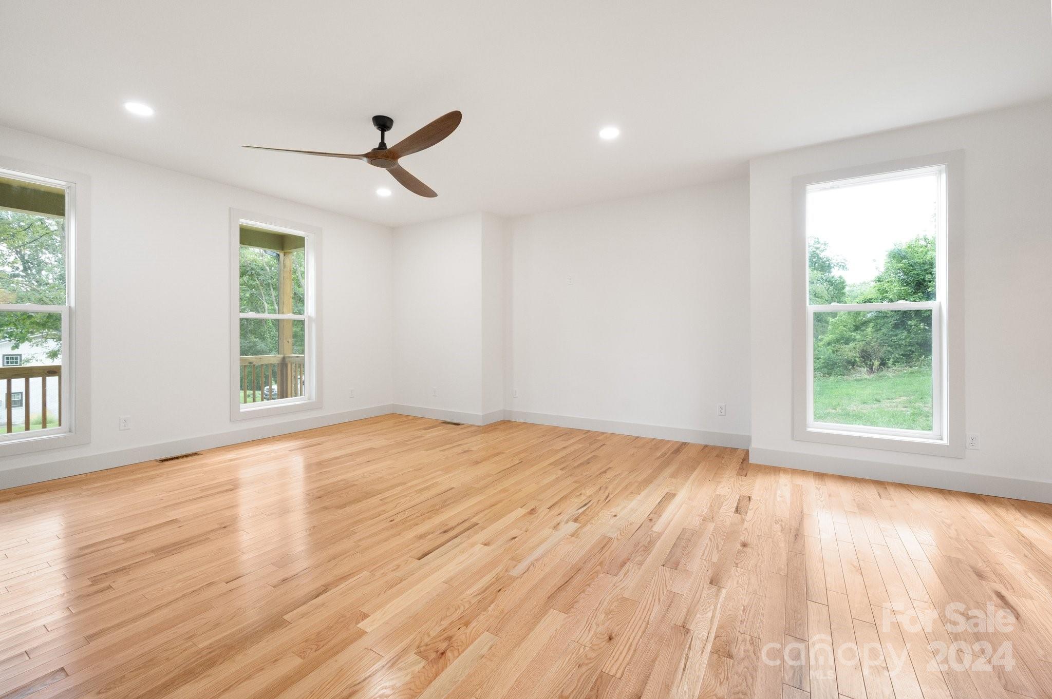 30 Spaulding Road Candler, NC 28715 - Photo 12 of 44 an empty room with wooden floor and windows