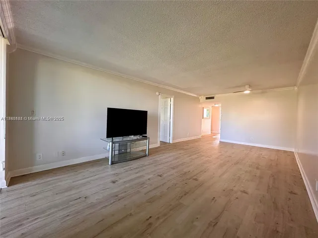 a view of a livingroom with wooden floor and a flat screen tv