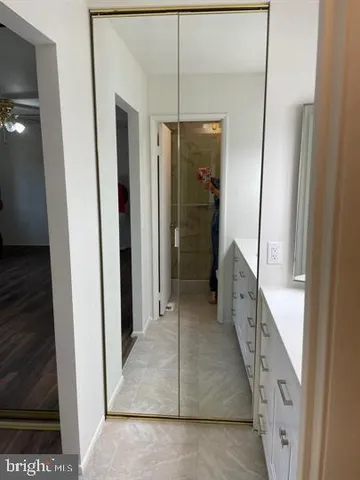 a bathroom with a granite countertop shower a sink and a mirror