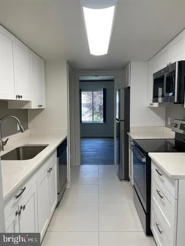 a kitchen with stainless steel appliances granite countertop a sink and dishwasher a stove top oven with wooden floor