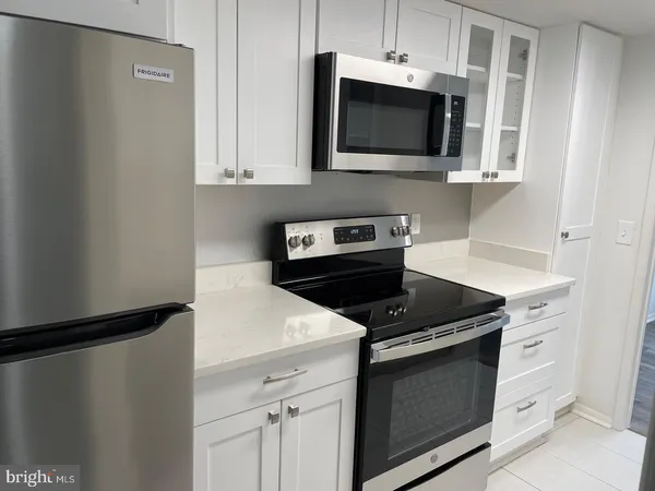 a kitchen with stainless steel appliances a stove microwave and refrigerator