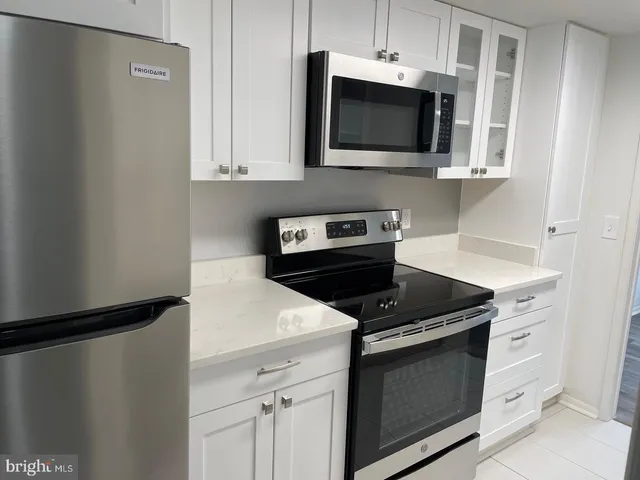 a kitchen with stainless steel appliances a stove microwave and refrigerator
