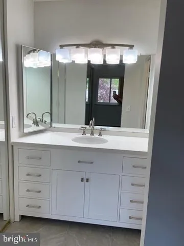 a bathroom with a sink vanity and a mirror