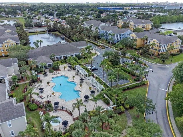 an aerial view of a residential houses with outdoor space and lake view