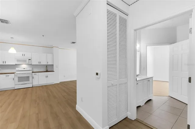 a kitchen with a refrigerator and white cabinets