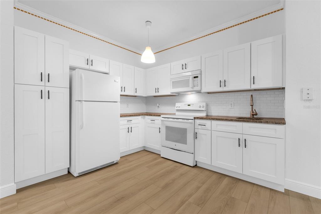 3561 Conroy Road, Unit 216 Orlando, FL 32839 - Photo 9 of 32 a kitchen with cabinets stainless steel appliances and wooden floor