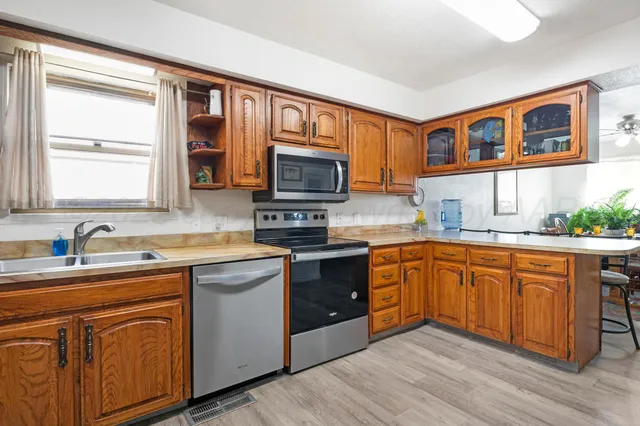 a kitchen with stainless steel appliances granite countertop wooden cabinets stove top oven and sink
