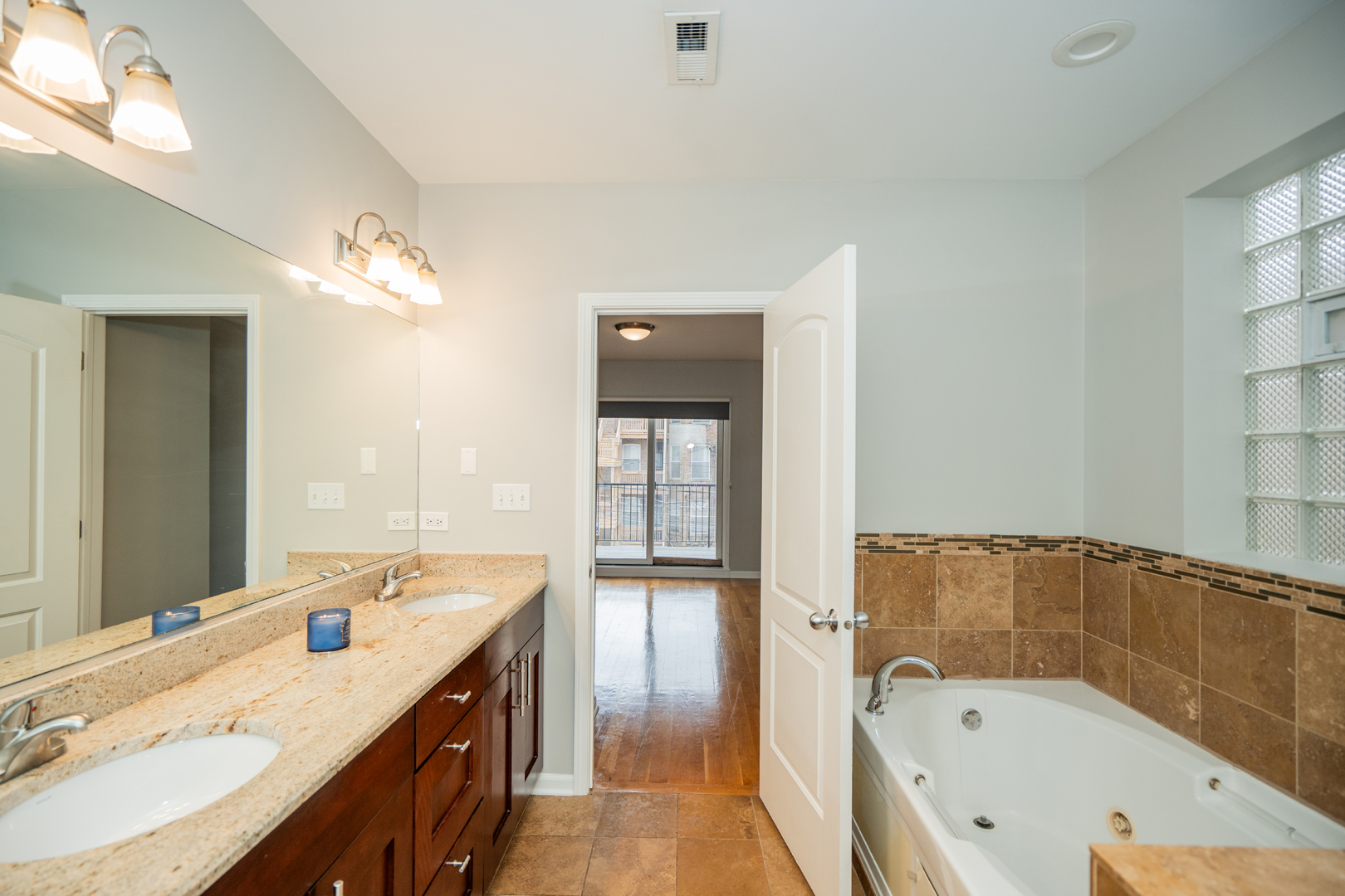 6543 South Ingleside Avenue, Unit 2 Chicago, IL 60637 - Photo 11 of 15 a bathroom with a granite countertop tub sink and mirror