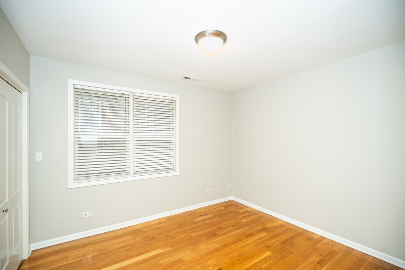 6543 South Ingleside Avenue, Unit 2 Chicago, IL 60637 - Photo 6 of 15 a view of an empty room with wooden floor and a window