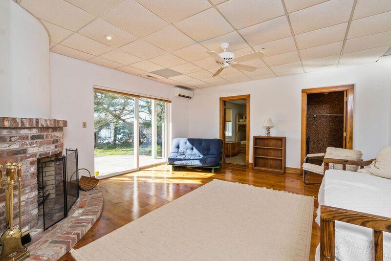 73 Barley Neck Road Orleans, MA 02653 - Photo 24 of 35 a living room with furniture large window and a fireplace