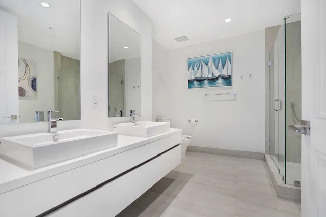 a bathroom with a sink a mirror and a potted plant