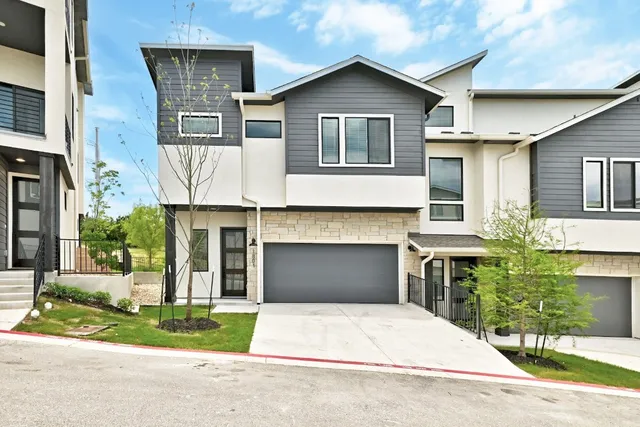a front view of a house with a yard and a garage
